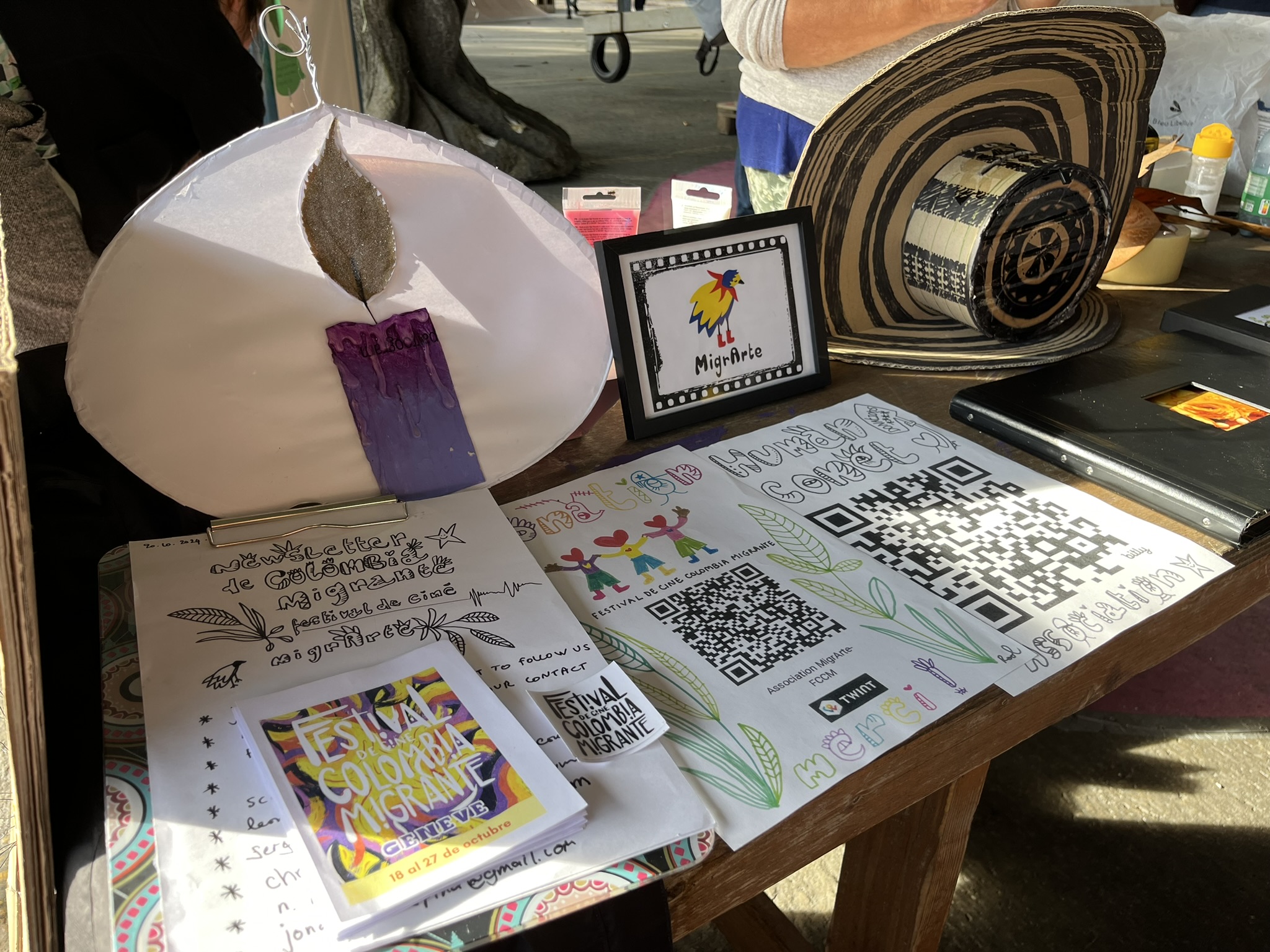 Mesa del festival con materiales impresos y códigos QR durante la edición 2024